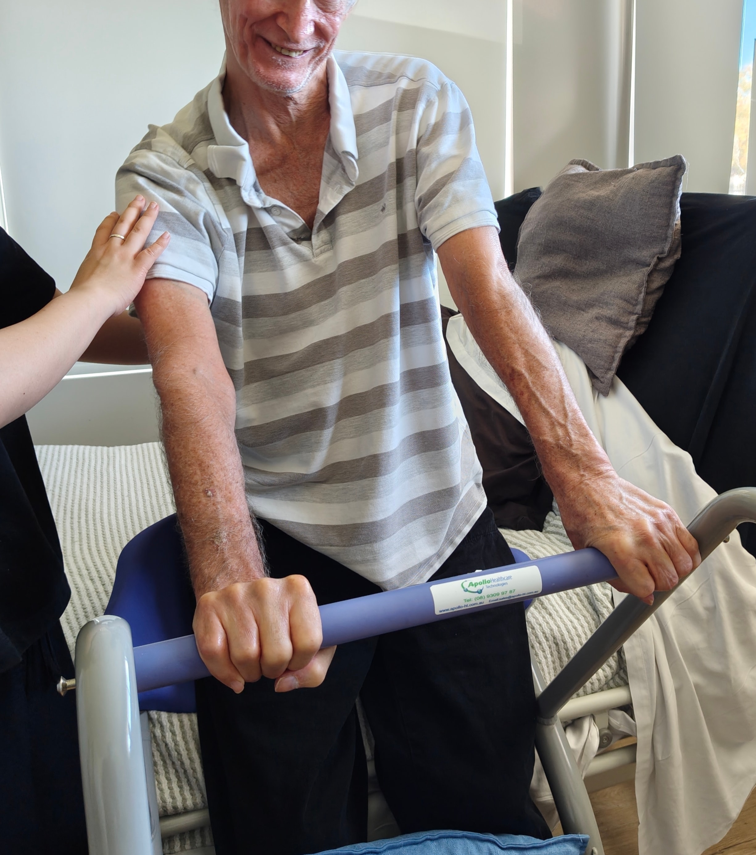 Physiotherapist assisting a patient with standing and mobility using a walking frame